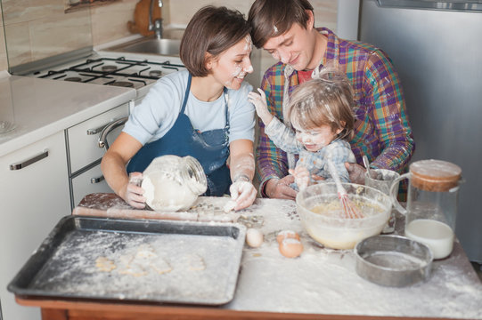 Young Family Having Fun With Flour At Messy Kitchen While Baking