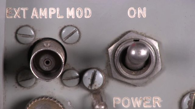 Close-up macro of old fashioned output toggle switch being turned on then off on radio transceiver vintage electronic hardware engineering equipment