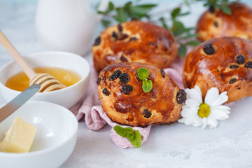 A beautiful breakfast, a date, buns with raisins, butter and honey, flowers. Valentine's Day concept.