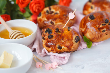 A beautiful breakfast, a date, buns with raisins, butter and honey, a bouquet of roses. Valentine's Day concept.