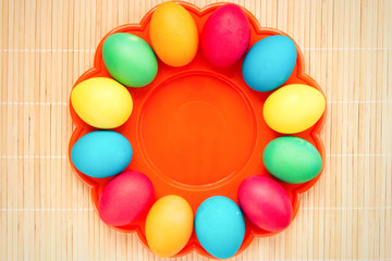 Easter concept painted eggs on wooden table in plate for holiday with place for text pattern with frame