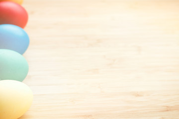 Easter concept painted eggs on wooden table in plate for holiday with place for text pattern with glow