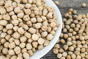 dry chickpea pictures in the bowl over the wooden floor,
ready to cook dried chickpeas dish

