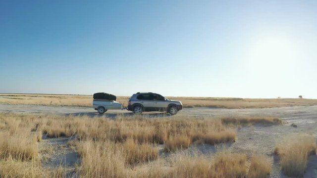 SUV pulling trailer on flat plains of the Makgadikgadi salt pans