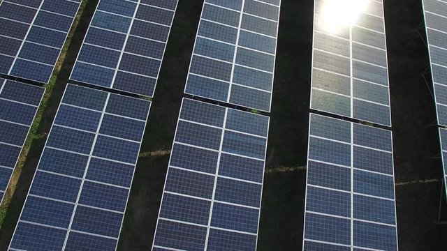 Solar panels with sun light shining, aerial view