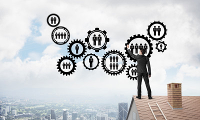 Businessman on house roof presenting teamwork and connection concept. Mixed media