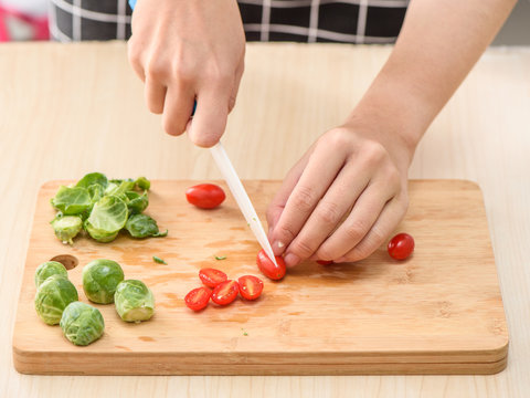 the process of chef cooking - cutting tomatoes on cutting board
