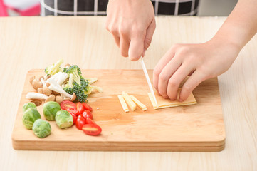 the process of chef cooking - cutting cheese pieces on cutting board
