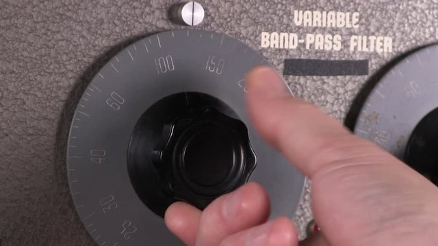 Close-up macro of decreasing input cut-off frequency dial adjustment to variable band-pass filter vintage electronic hardware engineering military equipment