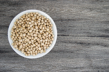 dry chickpea pictures in the bowl over the wooden floor,
ready to cook dried chickpeas dish

