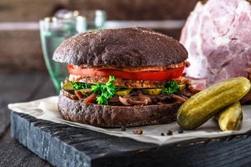 Homemade rye sandwich with ham, tomato, onion, pickles and two glasses of cold vodka.