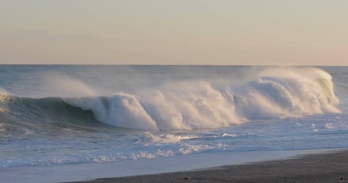 Oceano e mare mosso in tempesta con onde impetuose che si infrangono sulla spiaggia.