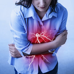 Female suffering from strong stomach ache abdominal pain.
