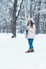 Fototapeta na wymiar attractive woman in winter clothing with coffee to go on winter day in park