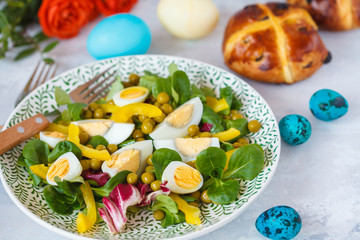 Fototapeta na wymiar Spring Easter salad with chicken and quail eggs, cross buns, painted eggs. Easter concept.