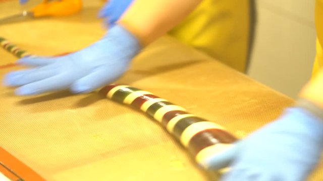 Manufacture of handmade caramel candies, closeup of making long candies. Women making a sweet candy. Pastry chef making sugar candies in confectionery
