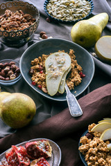 overhead view of bowl with granola and pear on tabletop