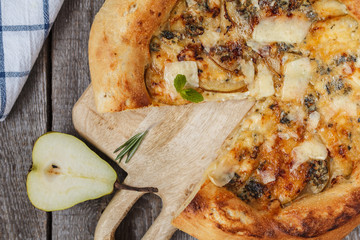 Hot delicous pizza with pear and blue cheese on wooden board. Vegetarian healthy food concept. Top view.