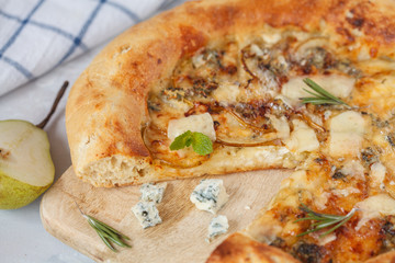 Hot delicous pizza with pear and blue cheese on wooden board. Vegetarian healthy food concept