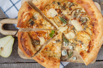 Hot delicous pizza with pear and blue cheese on wooden board. Vegetarian healthy food concept