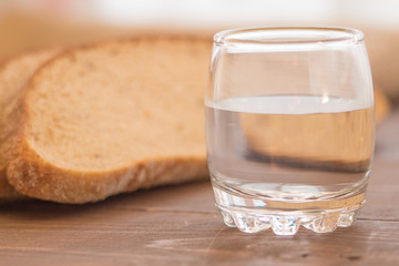 Homemade rustic loaf of rye bread a glass of water