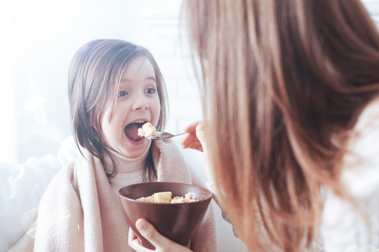 Open Your Mouth. Funny Girl Keeping Her Mouth And Eyes Wide Opened And Looking Forward While Eating Dinner