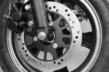 New brake disc on the front wheel of motobike - black and white