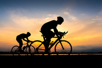 Cyclist in maximum effort in a road outdoors at sunset
