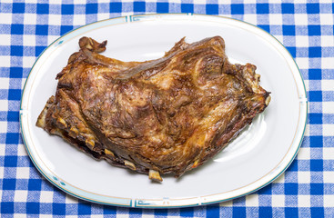a large piece of roasted pork on a plate, close up