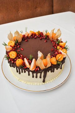 Chocolate cake with pomegranate, citrus fruits and fizalis. Dessert
