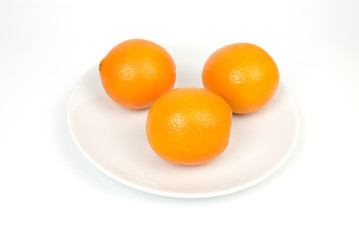 Orange on a white plate on a white backdrop.