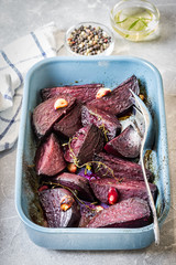 Roasted garlic thyme beetroot in a baking dish. Selective focus, copy space.
