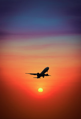 Fototapeta na wymiar Silhouette plane flying above mountain at during sunset.