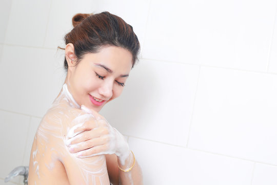 Woman taking a shower enjoying with foam bath.