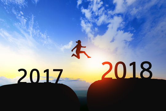 Woman jump through the gap between 2017 to 2018 on sunset.