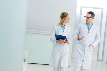 two doctors in white coats discussing diagnosis in hospital