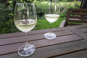 white wine glasses on wooden table at garden