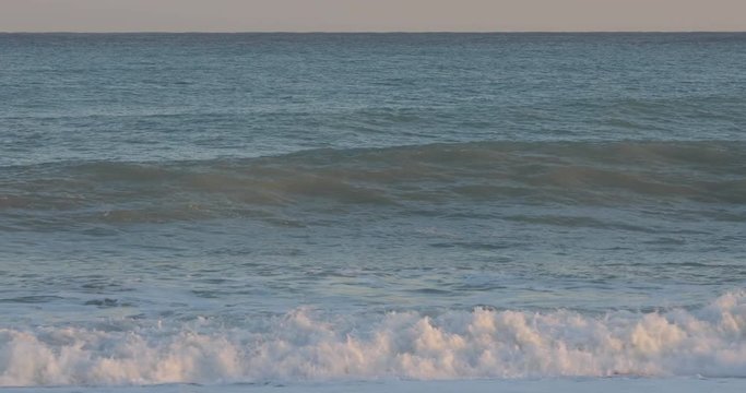 Oceano e mare mosso in tempesta con onde impetuose che si infrangono sulla spiaggia.
