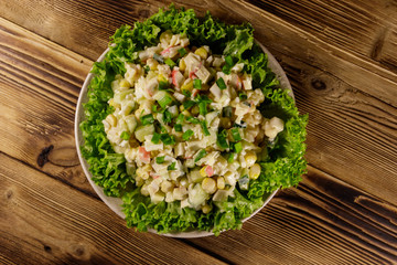 Obraz na płótnie Canvas Salad with crab sticks, sweet corn, cucumber, eggs, rice and mayonnaise