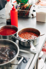 close-up shot of sauces in pans at restaurant kitchen