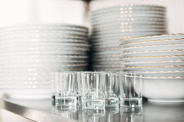 close-up shot of stacked clean tableware and glasses at restaurant