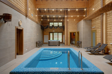 The pool with steps, a jacuzzi, a mow and chaise lounges