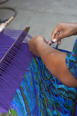 Hands of a Latina Maya woman, working on a typical loom in Guatemala, Central America.