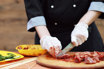 The cook cuts meat for cooking barbecue