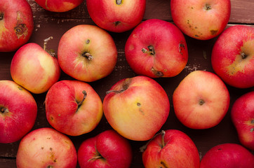Red apple on brown wooden table. Fresh fruits on background. Healthy food.