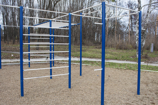 Sports bars in blue and white on the background of park for training in athletics. Outdoor athletic gym equipment. Concept of sport.