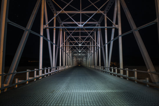 Illuminated empty metal bridge at night