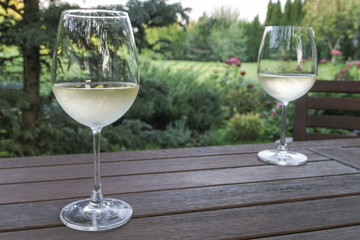 white wine glasses on wooden table at garden