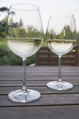 white wine glasses on wooden table at garden