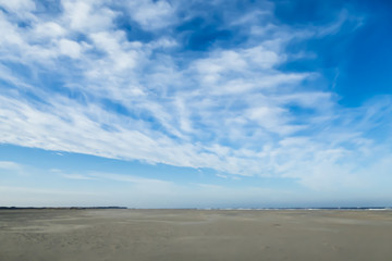 Blauer Himmel mit breitem Sandstrand an Nordseeküste